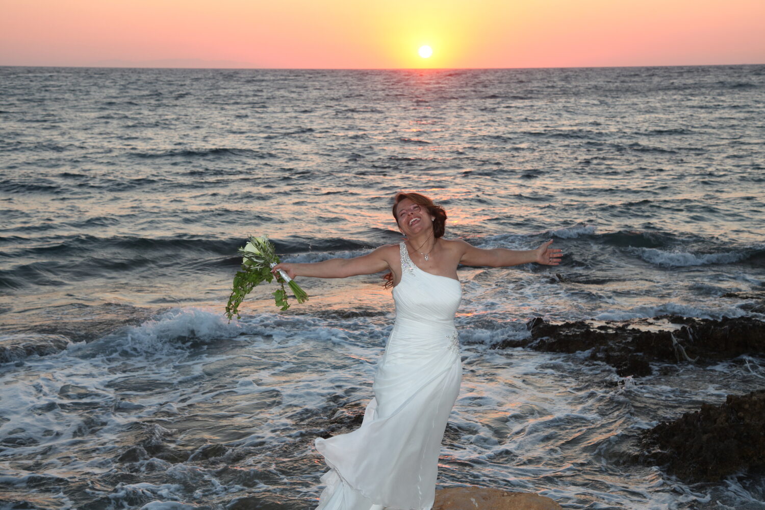 The bride in the sea at sunset