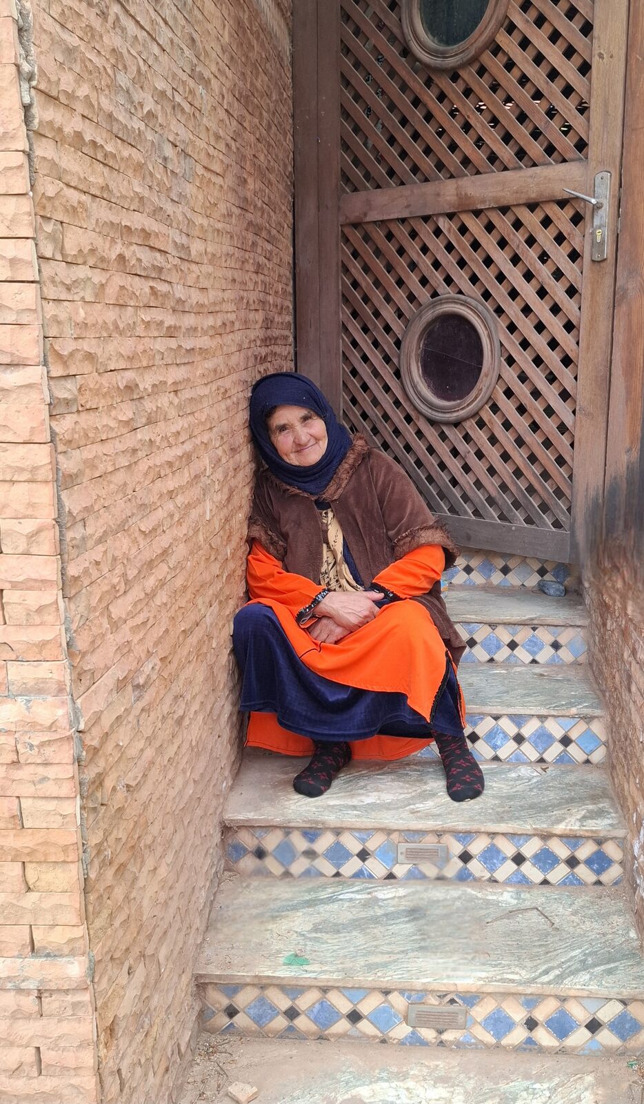 A local woman resting in a tiled doorway