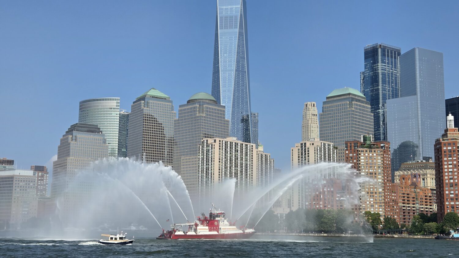 A fireboat spraying arcs of water in the harbor
