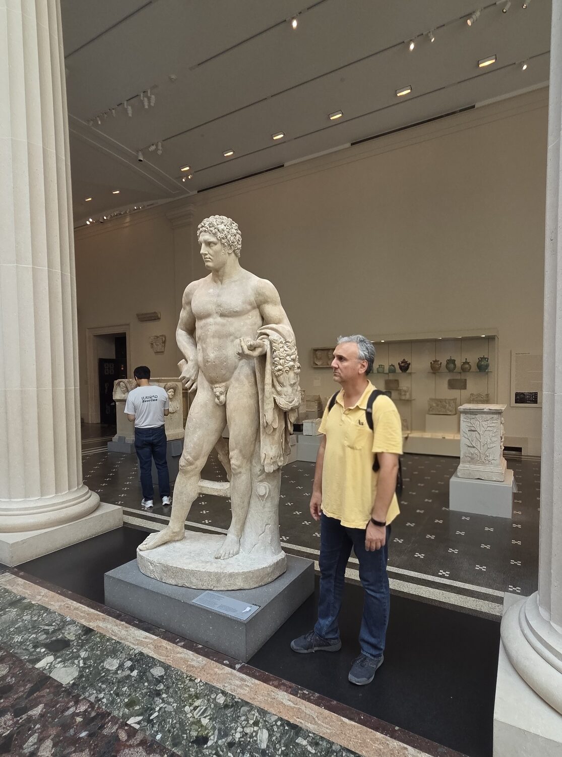 Plamen beside a marble statue of Hercules