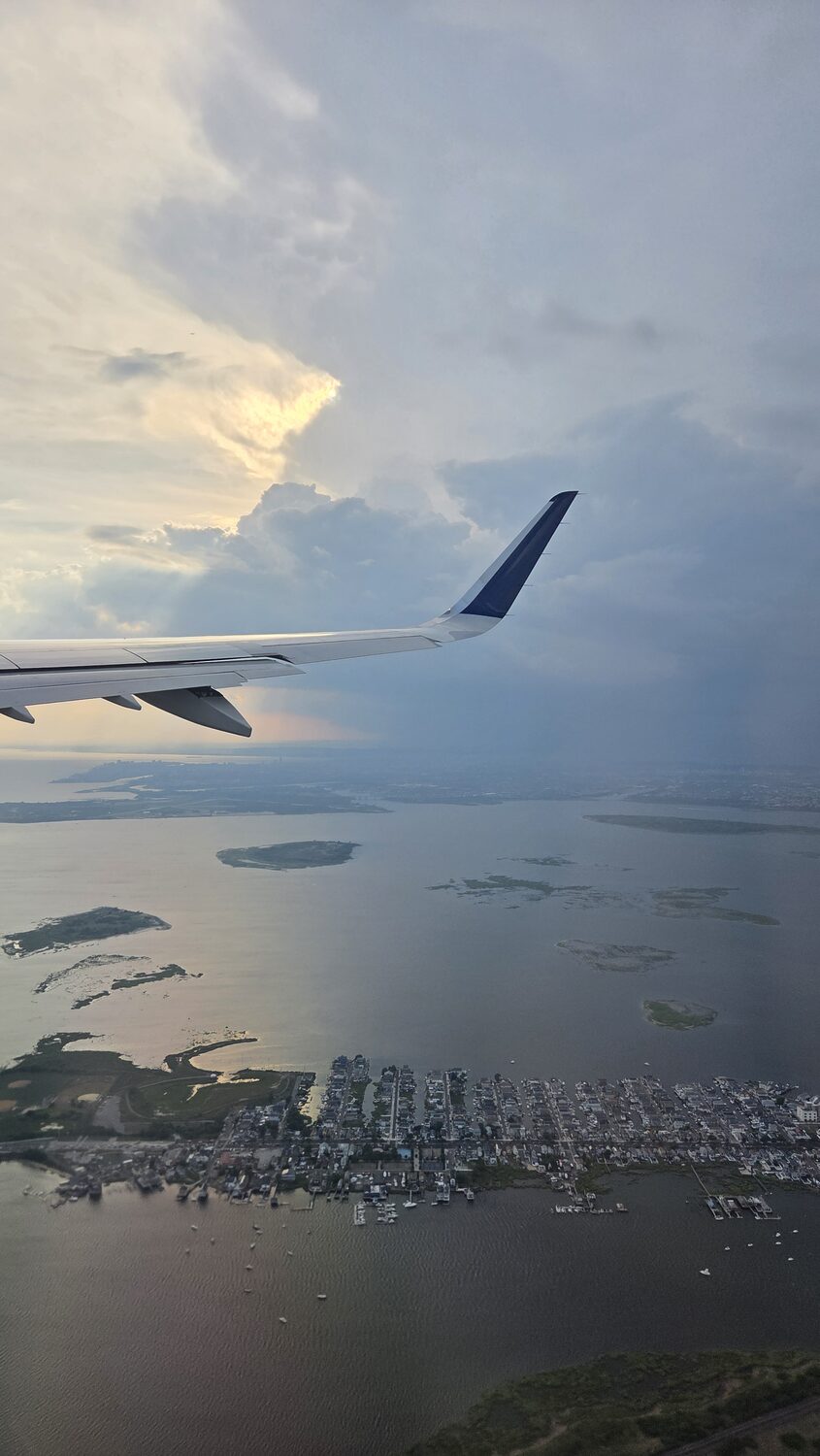The wing of the plane over the coast on the way home